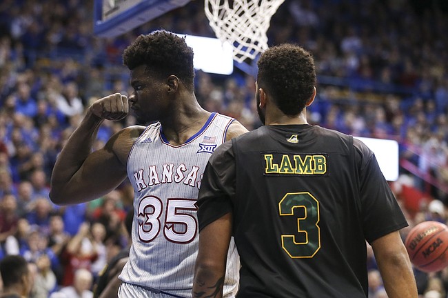 Kansas center Udoka Azubuike (35) flexes after a dunk before Vermont forward Anthony Lamb (3) during the first half, Monday, Nov. 12, 2018 at Allen Fieldhouse.