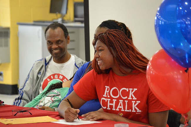 Lawrence High senior Chisom Ajekwu signs her national letter of intent Friday afternoon at LHS. Ajekwu is committed to play for KU women's basketball team at the collegiate level.