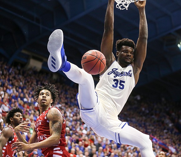 Kansas center Udoka Azubuike (35) hangs on the rim after a dunk before Louisiana forward Malik Marquetti (1) during the second half, Friday, Nov. 16, 2018 at Allen Fieldhouse.