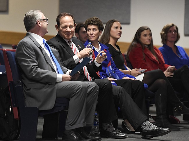 University of Kansas Athletic Director Jeff Long, left, and newly hired football coach Les Miles, second from left, share a smile Sunday, Nov. 18, 2018, at Hadl Auditorium.