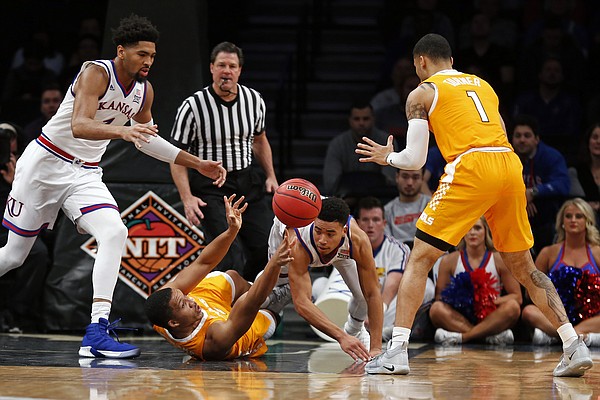 Tennessee forward Grant Williams passes the ball to Lamonte Turner, right, as Kansas forward Dedric Lawson, left, and guard Devon Dotson defend during the first half of an NCAA college basketball game in the NIT Season Tip-Off tournament Friday, Nov. 23, 2018, in New York. (AP Photo/Adam Hunger)