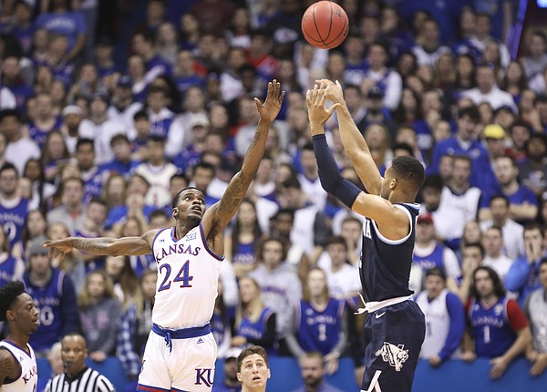 Villanova guard Phil Booth (5) puts up a three over Kansas guard Lagerald Vick (24) during the first half, Saturday, Dec. 15, 2018 at Allen Fieldhouse.