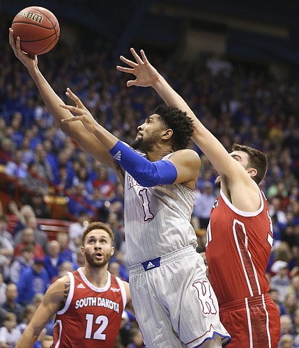 Kansas forward Dedric Lawson (1) squeezes in for a bucket past South Dakota forward Dan Jech (31) during the first half, Tuesday, Dec. 18, 2018 at Allen Fieldhouse.