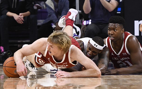 Oklahoma forward Brady Manek, left, Northwestern center Dererk Pardon, center, and Oklahoma forward Kristian Doolittle, right, fight for a loose ball during the second half of an NCAA college basketball game on Friday, Dec. 21, 2018, in Evanston, Ill. (AP Photo/Matt Marton)