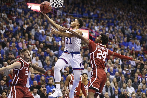 Kansas guard Devon Dotson (11) cruises in for a bucket past Oklahoma guard Jamal Bieniemy (24) during the first half, Wednesday, Jan. 2, 2019 at Allen Fieldhouse.