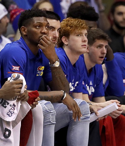 Kansas' Silvio De Sousa, left, watches from the bench during the first half of an NCAA college basketball game against Texas Monday, Jan. 14, 2019, in Lawrence, Kan. (AP Photo/Charlie Riedel)