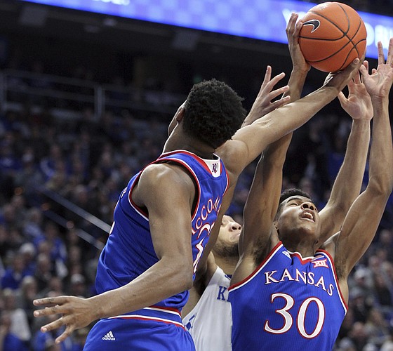Kansas' Ochai Agbaji (30) and teammate David McCormack, left, battle for a rebound with Kentucky's EJ Montgomery during the first half of an NCAA college basketball game in Lexington, Ky., Saturday, Jan. 26, 2019.