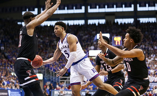 Kansas guard Quentin Grimes (5) gets around Texas Tech forward Khavon Moore (21) to throw a pass in the paint during the second half, Saturday, Feb. 2, 2019 at Allen Fieldhouse.