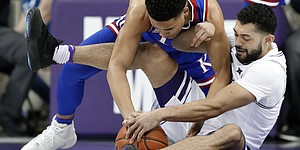 Kansas guard Devon Dotson, top, and TCU guard Alex Robinson, bottom, wrestle for control of a loose ball in the first half of an NCAA college basketball game in Fort Worth, Texas, Monday, Feb. 11, 2019. (AP Photo/Tony Gutierrez)