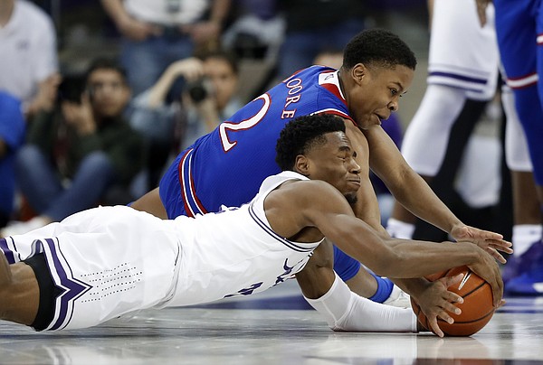 TCU guard RJ Nembhard, front, and Kansas guard Charlie Moore (2) wrestle on the floor for control of a loose ball in the first half of an NCAA college basketball game in Fort Worth, Texas, Monday, Feb. 11, 2019. (AP Photo/Tony Gutierrez)