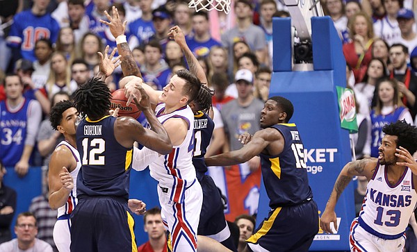 Kansas forward Mitch Lightfoot (44) battles in the paint for a ball with West Virginia forward Andrew Gordon (12) during the first half, Saturday, Feb. 16, 2019 at Allen Fieldhouse.