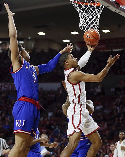 Oklahoma guard Miles Reynolds, right, tries to score in front of Kansas guard Quentin Grimes, left, in the second half of an NCAA college basketball game in Norman, Okla., Tuesday, March 5, 2019. Oklahoma won 81-68. (AP Photo/Nate Billings)