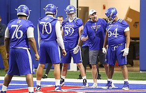 Kansas offensive line coach Luke Meadows gives instruction to lineman Jalan Robinson (54) during football practice on Wednesday, March 6, 2019 within the new indoor practice facility.