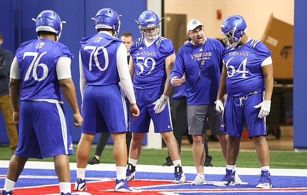 Kansas offensive line coach Luke Meadows gives instruction to lineman Jalan Robinson (54) during football practice on Wednesday, March 6, 2019 within the new indoor practice facility.