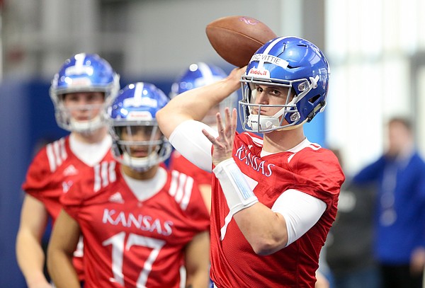 Kansas quarterback Thomas MacVittie pulls back to throw during football practice on Wednesday, March 6, 2019 within the new indoor practice facility.