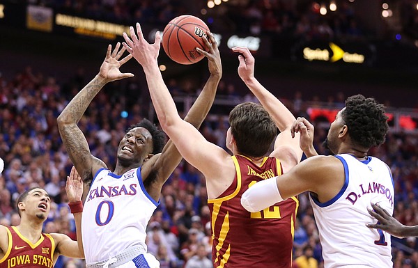 Kansas guard Marcus Garrett (0) grabs an offensive rebound from Iowa State forward Michael Jacobson (12) during the first half, Saturday, March 16, 2019 at Sprint Center in Kansas City, Mo.