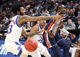 Auburn guard Jared Harper (1) hooks a pass around Kansas guard K.J. Lawson (13) and Kansas guard Charlie Moore (2) late in the second half on Saturday, March 23, 2019 at Vivint Smart Homes Arena in Salt Lake City, Utah.