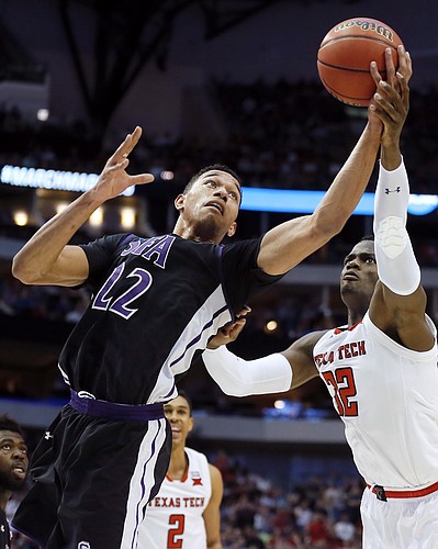Stephen F. Austin forward TJ Holyfield (22) and Texas Tech forward Norense Odiase (32) battle for a rebound during the first half of a first-round game at the NCAA college basketball tournament in Dallas, Thursday, March 15, 2018. (AP Photo/Brandon Wade)
