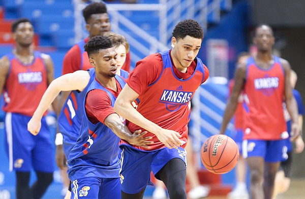 Kansas freshman Tristan Enaruna pushes the ball up the court as fellow freshman Isaac McBride defends during a scrimmage on Tuesday, June 11, 2019 at Allen Fieldhouse.