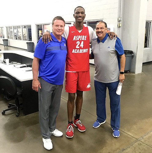 Gethro Muscadin during a recent visit with KU coaches Bill Self and Kurtis Townsend. Photo courtesy @aspireacademyky 