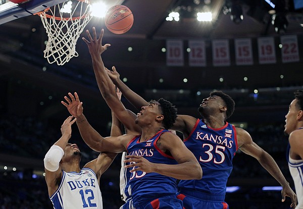 Duke forward Javin DeLaurier (12) vies for a rebound with Kansas forward David McCormack and center Udoka Azubuike (35) during the first half of an NCAA college basketball game Tuesday, Nov. 5, 2019, in New York. (AP Photo/Adam Hunger)