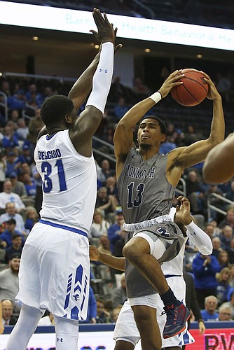 Monmouth's Marcus McClary (13) attempts a shot as Seton Hall's Angel Delgado (31) defends during the first half of an NCAA college basketball game in Newark, N.J., Sunday, Nov. 12, 2017. (AP Photo/Rich Schultz)