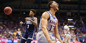 Kansas guard Tristan Enaruna (13) celebrates after a breakaway windmill dunk during the second half against Monmouth on Friday, Nov. 15, 2019 at Allen Fieldhouse.