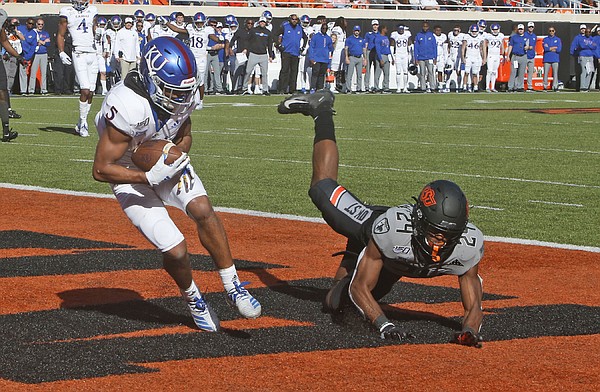 Kansas wide receiver Stephon Robinson Jr. (5) scores a touchdown in front of Oklahoma State safety Jarrick Bernard (24) in the second half of an NCAA college football game in Stillwater, Okla., Saturday, Nov. 16, 2019. (AP Photo/Sue Ogrocki)