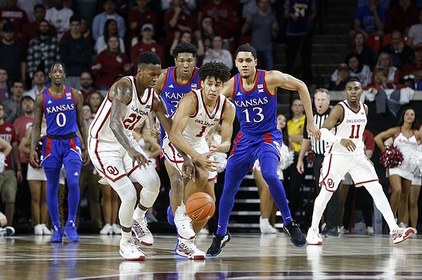 Oklahoma's Jalen Hill (1) and Kristian Doolittle (21) fight for the ball with Kansas' Chris Teahan (12) and David McCormack (33) during the second half of an NCAA college basketball game in Norman, Okla., Tuesday, Jan. 14, 2020. (AP Photo/Garett Fisbeck)