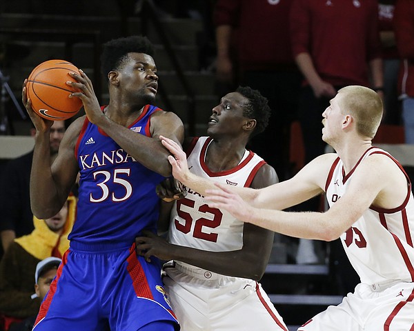 Kansas' Udoka Azubuike (35) is defended by Oklahoma's Kur Kuath (52) and Brady Manek (35) during the second half of an NCAA college basketball game in Norman, Okla., Tuesday, Jan. 14, 2020. (AP Photo/Garett Fisbeck)