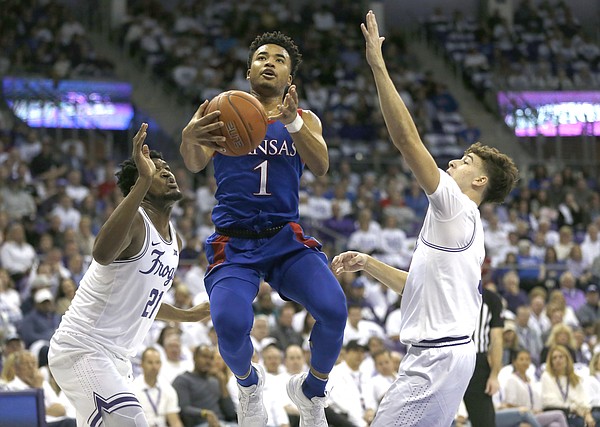 Kansas guard Devon Dotson (1) handles the ball inside a TCU center Kevin Samuel (21) and guard Francisco Farabello (3) defend during the first half of an NCAA college basketball game, Saturday, Feb. 8, 2020, in Fort Worth, Texas. (AP Photo/Ron Jenkins)
