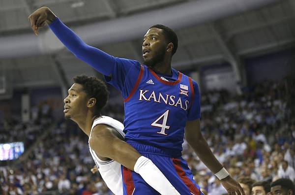 Kansas guard Isaiah Moss (4) scores on a 3-point shot as TCU forward Diante Smith (10) looks on during the first half of an NCAA college basketball game, Saturday, Feb. 8, 2020, in Fort Worth, Texas. (AP Photo/Ron Jenkins)