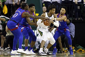 Kansas guard Marcus Garrett, left, and guard Devon Dotson, right, pressure Baylor forward Freddie Gillespie, center, during the first half of an NCAA college basketball game on Saturday, Feb. 22, 2020, in Waco, Texas. (AP Photo/Ray Carlin)