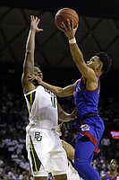 Kansas guard Devon Dotson, right, shoots over Baylor guard Mark Vital, left, during the first half of an NCAA college basketball game on Saturday, Feb. 22, 2020, in Waco, Texas. (AP Photo/Ray Carlin)