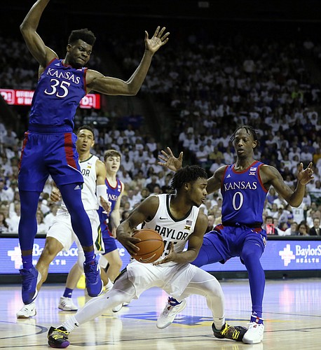 Baylor guard Davion Mitchell, center, is defended by Kansas center Udoka Azubuike, left, and guard Marcus Garrett, right, during the second half of an NCAA college basketball game on Saturday, Feb. 22, 2020, in Waco, Texas. (AP Photo/Ray Carlin)