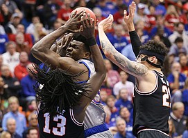 Kansas center Udoka Azubuike is doubled teamed by Oklahoma State guard Isaac Likekele (13) and Oklahoma State guard Lindy Waters III (21) during the first half on Monday, Feb. 24, 2020 at Allen Fieldhouse.