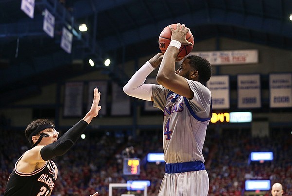 Kansas guard Isaiah Moss (4) pulls up from the corner over Oklahoma State guard Lindy Waters III (21) during the first half on Monday, Feb. 24, 2020 at Allen Fieldhouse.
