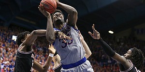Kansas center Udoka Azubuike (35) powers through a triple team to the bucket during the second half against Oklahoma State on Monday, Feb. 24, 2020 at Allen Fieldhouse.