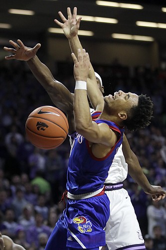Kansas guard Devon Dotson (1) is fouled by Kansas State forward Makol Mawien, back, during the first half of an NCAA college basketball game in Manhattan, Kan., Saturday, Feb. 29, 2020. (AP Photo/Orlin Wagner)
