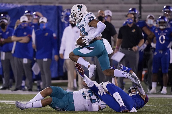 Coastal Carolina cornerback Derick Bush (23) leaps over players after intercepting a pass during the first half of an NCAA college football game in Lawrence, Kan., Saturday, Sept. 12, 2020. (AP Photo/Orlin Wagner)