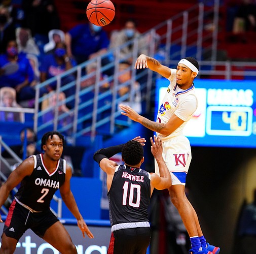 Kansas guard Dajuan Harris (3) throws a pass over Omaha guard Ayo Akinwole (10) during the first half on Friday, Dec. 11, 2020 at Allen Fieldhouse.
