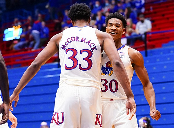 Kansas forward David McCormack (33) throws a chest bump to Kansas guard Ochai Agbaji (30) after a dunk during the second half on Friday, Dec. 11, 2020 at Allen Fieldhouse.