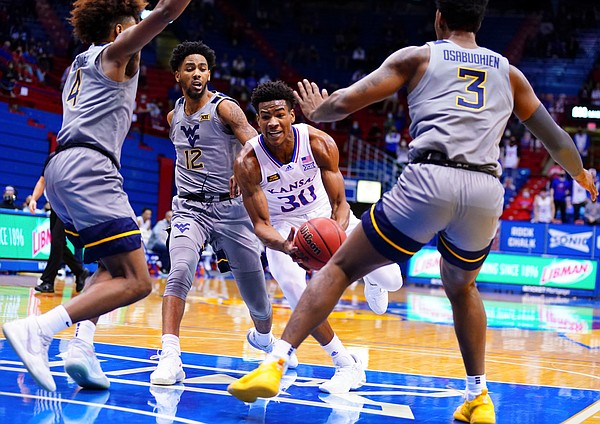 Kansas guard Ochai Agbaji (30) is surrounded in the paint by three West Virginia defenders during the first half, Tuesday, Dec. 22, 2020 at Allen Fieldhouse.