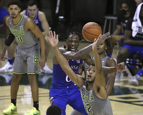 Baylor guard Jared Butler (12) and Kansas guard Marcus Garrett (0) reach for the ball in the second half of an NCAA college basketball game, Monday, Jan. 18, 2021, in Waco, Texas. (AP Photo/Jerry Larson)