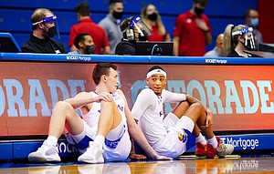 Kansas forward Mitch Lightfoot (44) and Kansas guard Dajuan Harris (3) have a chat while waiting to check in during the second half on Thursday, Jan. 28, 2021 at Allen Fieldhouse.
