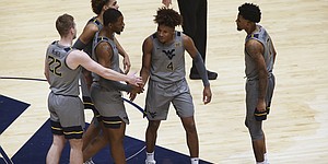 West Virginia players meet on the court during the second half of an NCAA college basketball game against Kansas, Saturday, Feb. 6, 2021, in Morgantown, W.Va. (AP Photo/Kathleen Batten)
