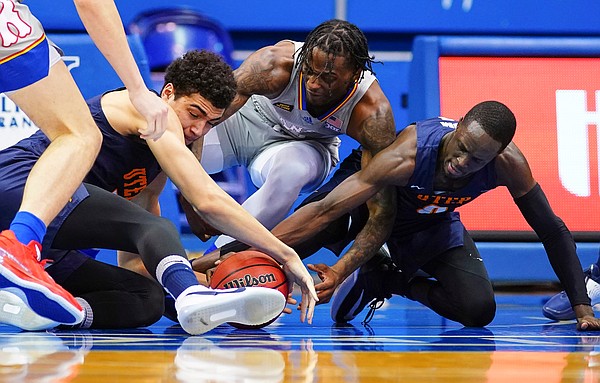Kansas guard Marcus Garrett (0) wrestles on the ground for a ball with UTEP forward Tydus Verhoeven, left, and UTEP guard Souley Boum (0) during the first half on Thursday, March 4, 2021 at Allen Fieldhouse.