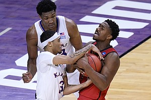 Kansas guard Dajuan Harris (3) battles Eastern Washington guard Kim Aiken Jr. (24) battle for the ball during the second half of a first-round game in the NCAA college basketball tournament at Farmers Coliseum in Indianapolis, Saturday, March 20, 2021. (AP Photo/AJ Mast)