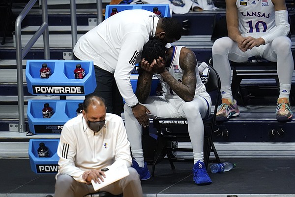 Kansas guard Marcus Garrett (0) is comforted by staff during the second half of a men's college basketball game in the second round of the NCAA tournament at Hinkle Fieldhouse in Indianapolis, Monday, March 22, 2021. USC won 85-51. (AP Photo/Paul Sancya)