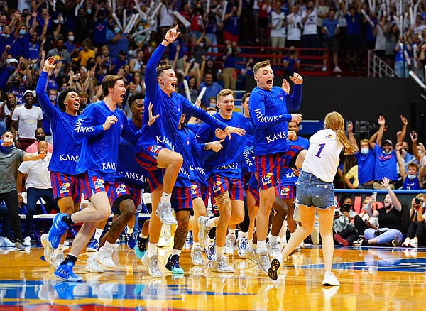 The Kansas men's basketball team rushes to the court to celebrate with Kansas sophomore Libby Frost of Wakeeney, Kan., after Frost hit a three-pointer for $5K of head coach Bill Self's money to split with another contestant during Late Night in the Phog, Friday, Oct. 1, 2021 at Allen Fieldhouse.